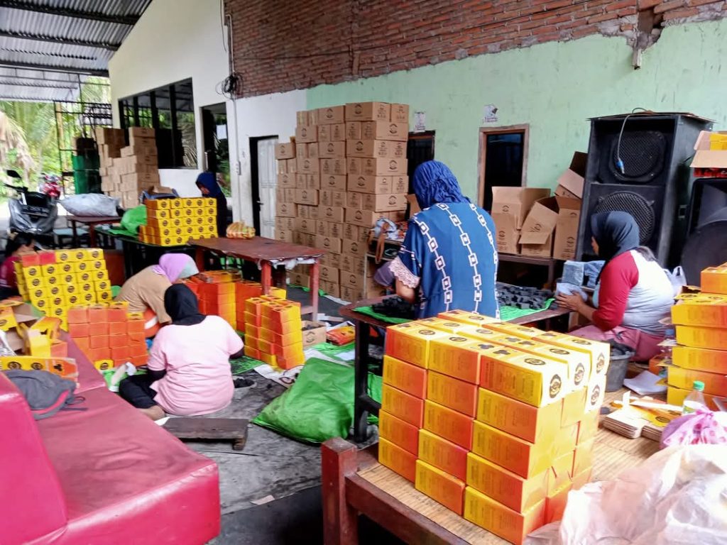 HSA Factory Charcoal Ein HSA-Mitarbeiter verpackt hochwertige Kokosnusskohle-Briketts mit Markenverpackung für den Export.